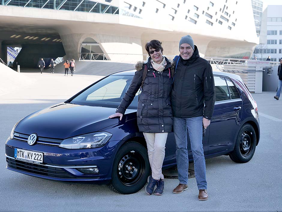 autoWOBil.de Jahreswagenzentrale: Frau und Herr M. bei der Abholung Ihres neuen Volkswagen Golf in Wolfsburg: Zufrieden mit Ihrem neuen Golf VII Limousine in Atlantik Blue-Metallic. 
